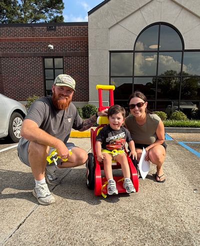 Family is shown with red and yellow Toddler Mobility Trainer